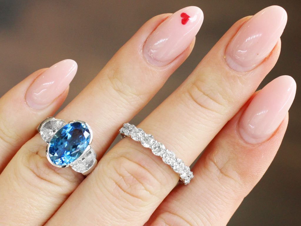 aquamarine ring on hand with diamond eternity ring