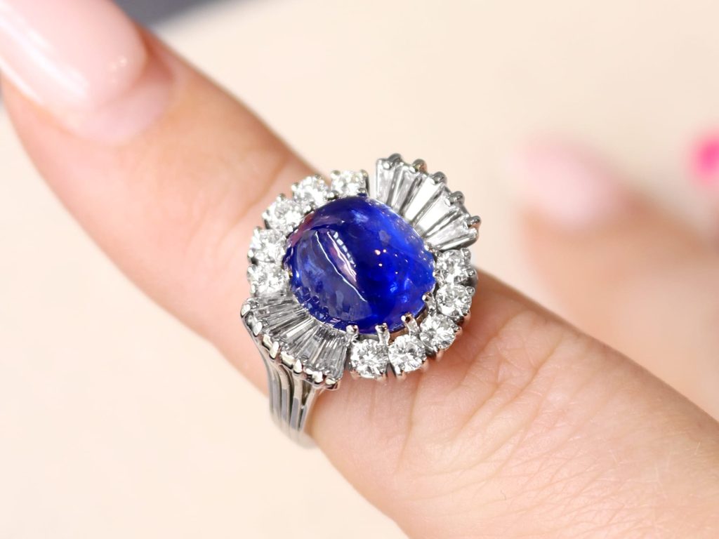 Burma sapphire and diamond cluster ring on finger