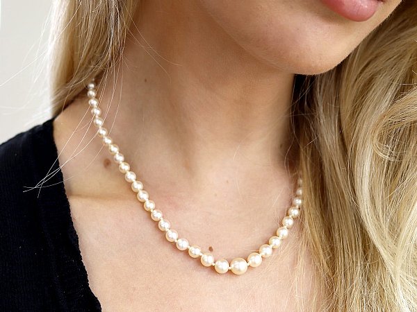 wearing single strand pearl necklace 