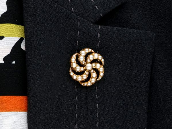 pearl and yellow gold brooch on jacket